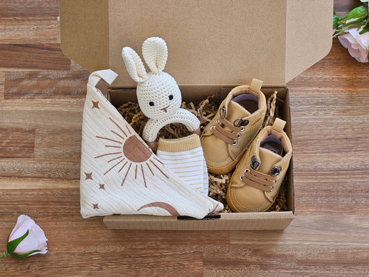 Baby shoe gift box includes brown walking boot. stripped socks, burp cloth and a crocheted rabbit rattle