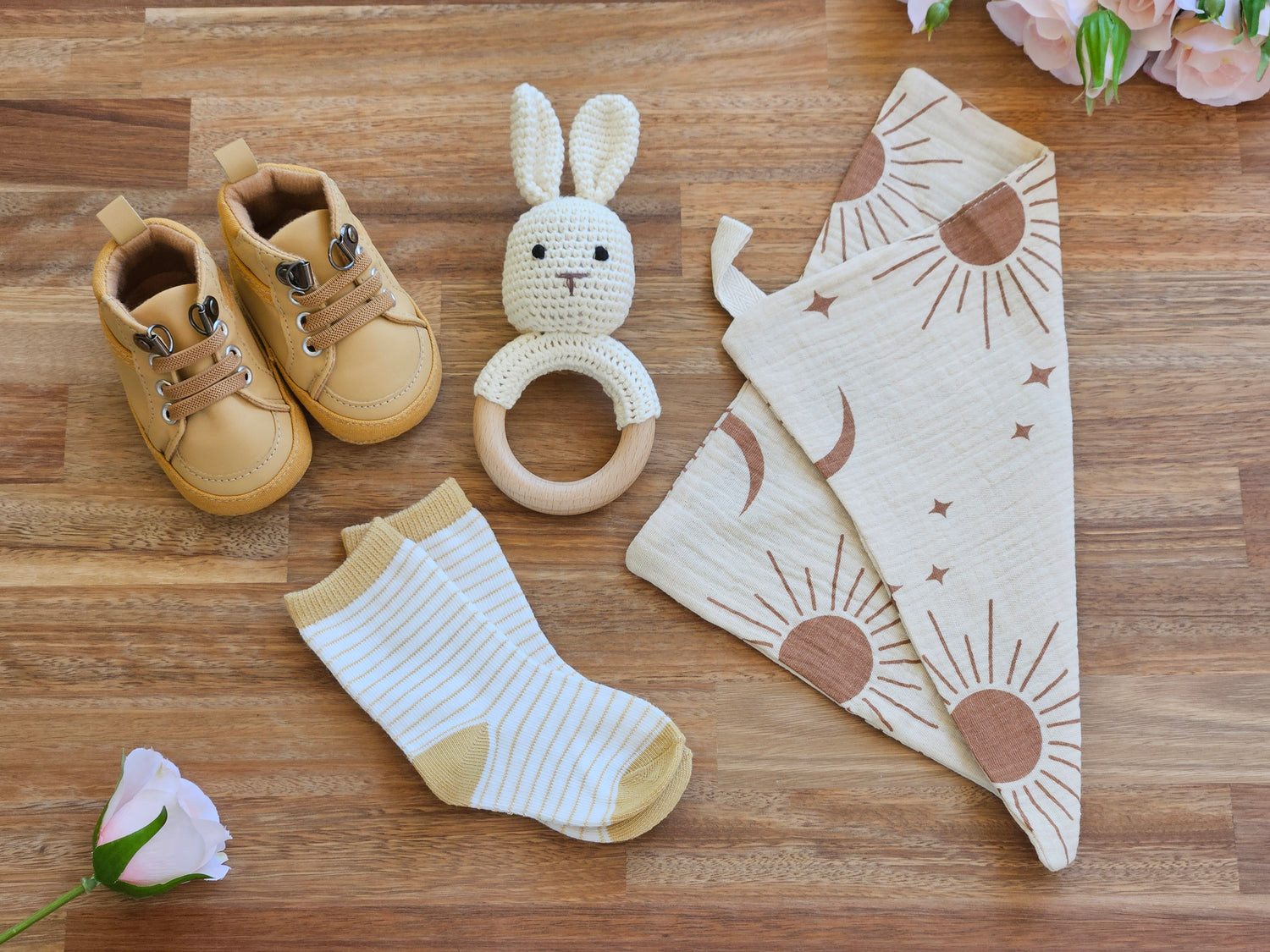 brown walking boot. stripped socks, burp cloth and a crocheted rabbit rattle