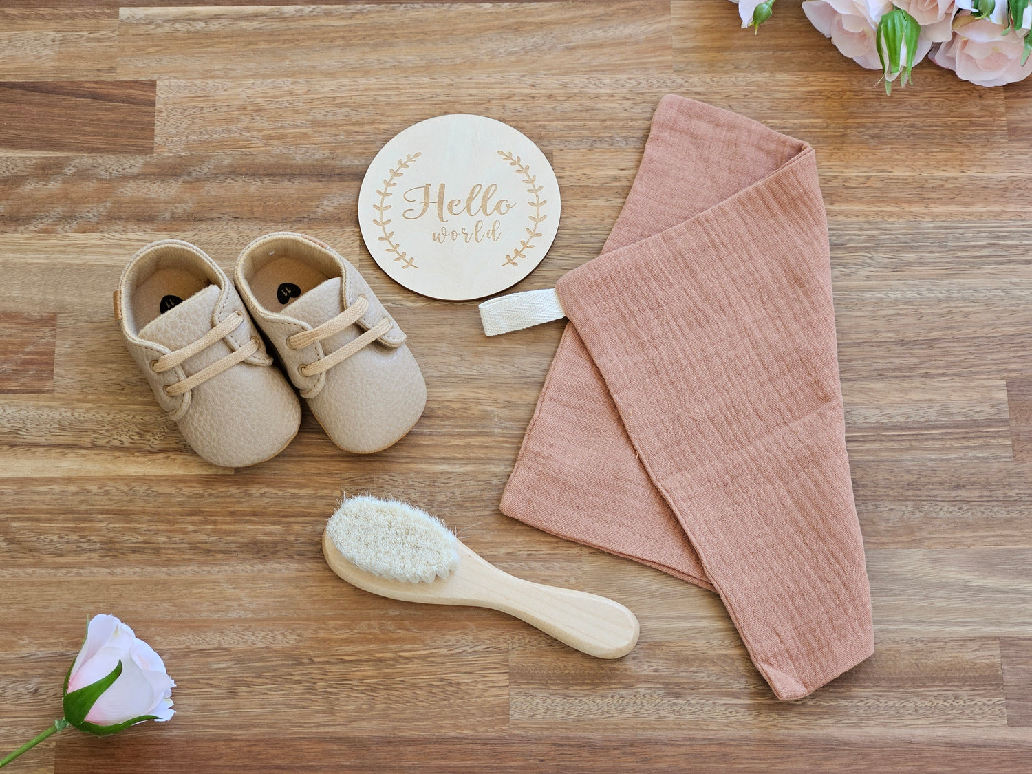 Brown lace up shoe, Muslin burp cloth, wooden hairbrush and a welcome to the world disc