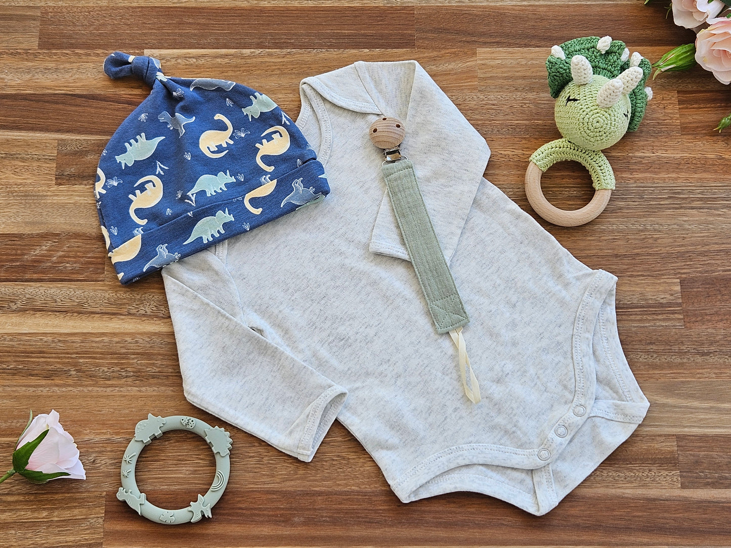 Dinosaur hat and beige romper with Triceratops rattle, Silicone teether and a muslin pacifier chain
