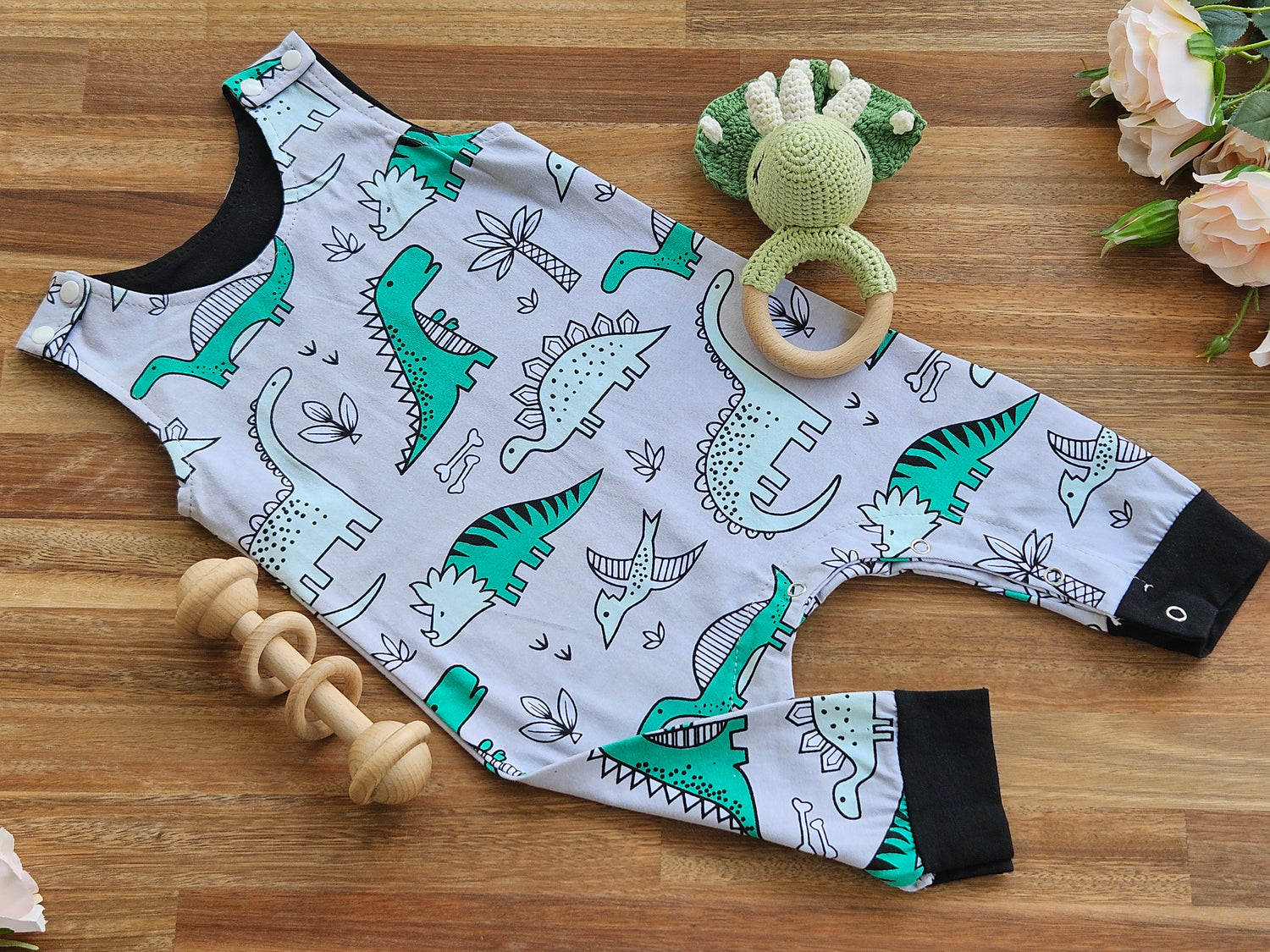 Cotton dinosaur overall style romper, crocheted dinosaur rattle and a wooden bar toy